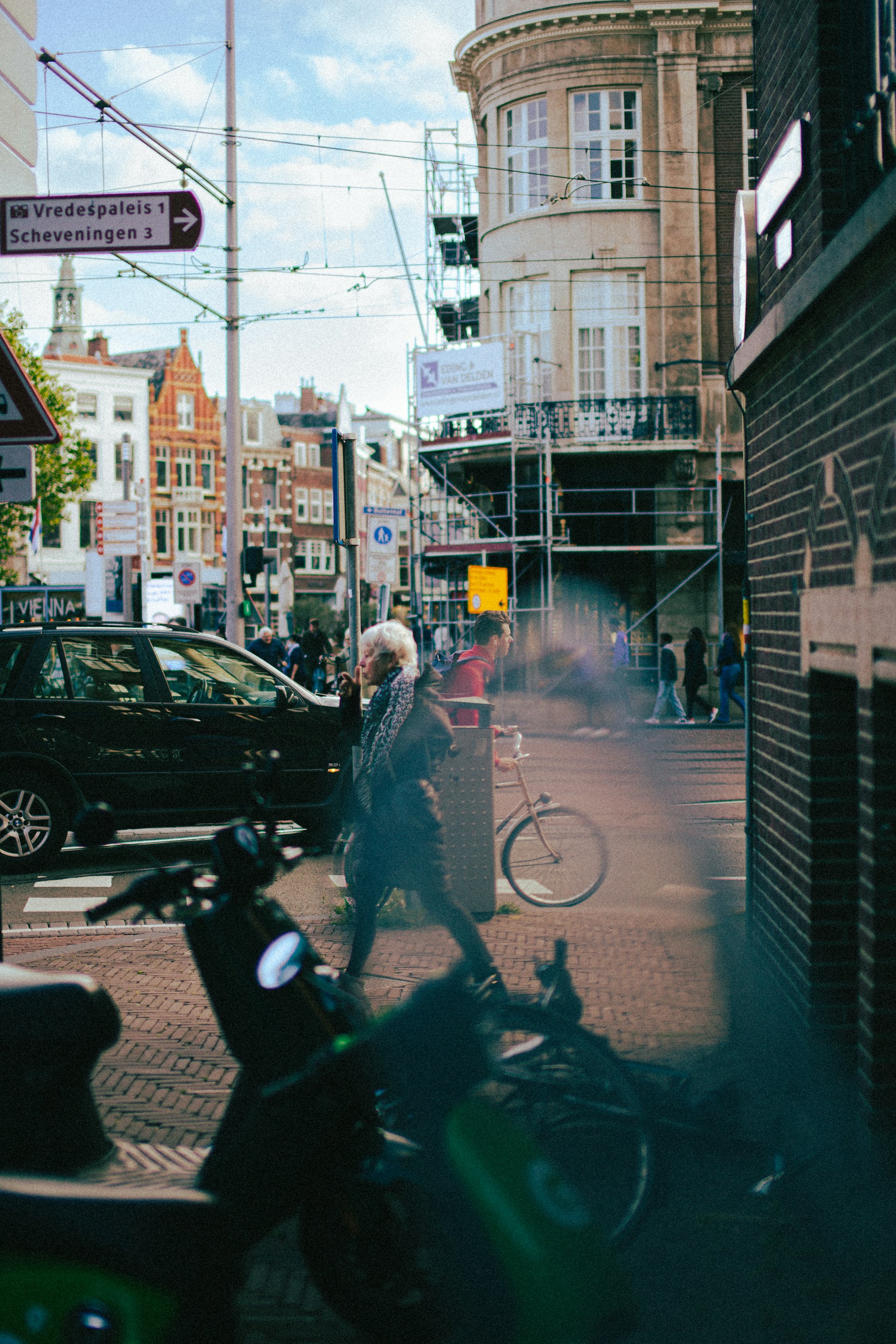 Een straatscène in de stad met auto's en gebouwen is zwaar vervormd door digitale glitches, waardoor de details gefragmenteerd zijn en kleuren strepen en kromgetrokken over het beeld lijken.